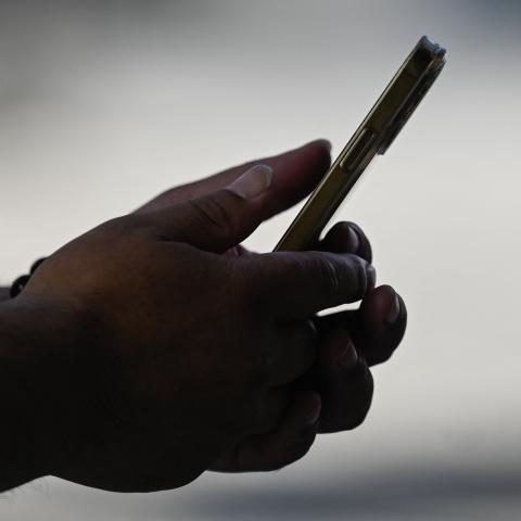 A man uses an Apple iPhone in Beijing on September 12, 2023. (Photo by Pedro Pardo/AFP via Getty Images)