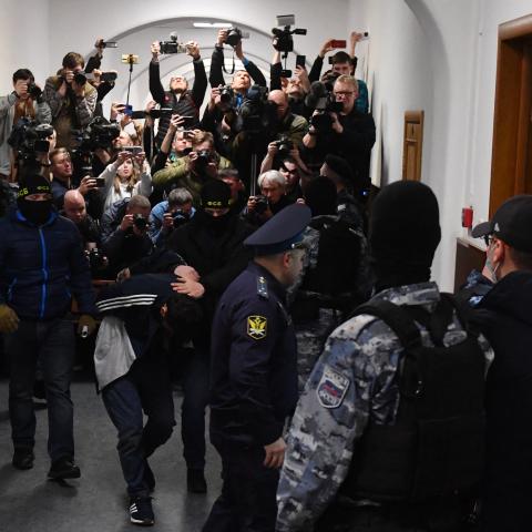 A man suspected of taking part in the attack of a concert hall that killed 137 peopleis escorted by Russian law enforcement officers at the Basmanny District Court in Moscow on March 24, 2024.  (Photo by Olga MALTSEVA / AFP) (Photo by OLGA MALTSEVA/AFP via Getty Images)