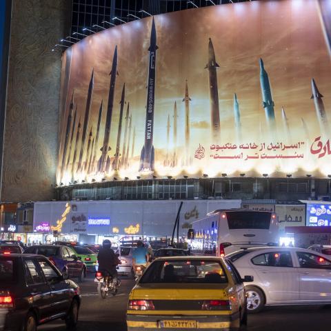 Vehicles drive under a massive billboard that is displays an illustrated image of Islamic Revolutionary Guards Corps missiles in Tehran, Iran, on April 15, 2024. (Photo by Morteza Nikoubazl/NurPhoto via Getty Images)