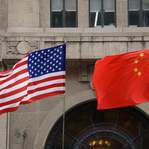 A US and a Chinese flag wave outside a commercial building in Beijing, July 9, 2007. (TEH ENG KOON/AFP via Getty Images)