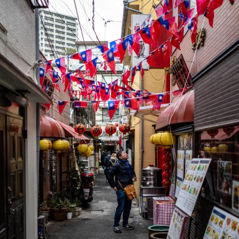 A man stands under Taiwanese flags on a street in the Chinatown section of Yokohama, Kanagawa prefecture, south of Tokyo on January 28, 2024. (Photo by Philip FONG / AFP) 