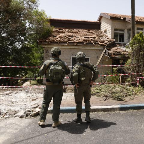 A picture taken during a tour with the Israeli army in Dovev, a Moshav in north Israel close to the border with Lebanon, shows Israeli soldiers inspecting the damage to a synagogue after it was hit by rockets fired from Lebanon on May 27, 2024. (Photo by Jalaa MAREY / AFP) (Photo by JALAA MAREY/AFP via Getty Images)