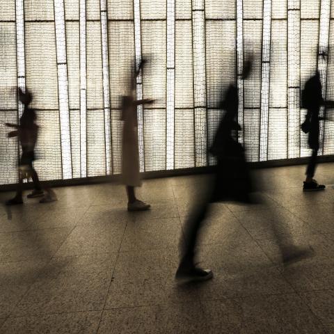 People are seen silhouetted against a storefront display in Hong Kong on September 27, 2020. (May James/AFP via Getty Images)