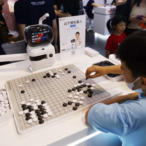 SHANGHAI, CHINA - JULY 6, 2023 - A Yuanradish chess robot displayed by SenseTime plays Go with a child at the 2023 World Artificial Intelligence Conference in Shanghai, China, July 6, 2023. (Photo credit should read CFOTO/Future Publishing via Getty Images)