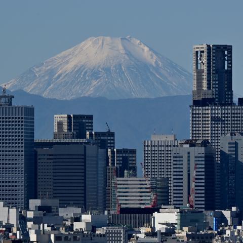 This picture taken on November 14, 2023 shows Japan's highest mountain, Mt. Fuji in the background between skyscrapers in Tokyo's Shinjuku area. (Photo by Kazuhiro NOGI / AFP) (Photo by KAZUHIRO NOGI/AFP via Getty Images)
