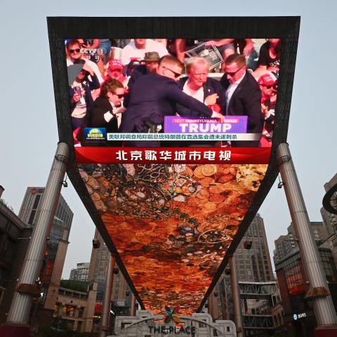 A news program about the assassination attempt on former President Donald Trump is being watched at a shopping mall in Beijing on July 14, 2024. (Greg Baker/AFP via Getty Images)