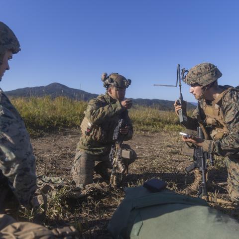 U.S. Marine Corps Sgt. Hunter Heinsohn, left, a signals intelligence operator and analyst, Cpl. Adam Domagalaski, right, an intelligence, surveillance and reconnaissance systems engineer, both with 3rd Radio Battalion, III Marine Expeditionary Force Information Group, coordinate an electronic attack 6-line with Lance Cpl. Jackie Wu, center, a rifleman with 2nd Battalion, 2nd Marine Regiment, 3d Marine Division, during the field training exercise portion of Resolute Dragon 23 at Japan Ground Self-Defense For