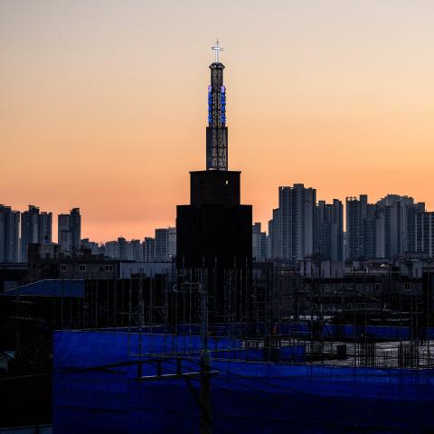 A general view shows a church (C) between a construction site (foreground) and residential and commercial buildings in Seoul on November 21, 2023. (Photo by Anthony WALLACE / AFP) (Photo by ANTHONY WALLACE/AFP via Getty Images)