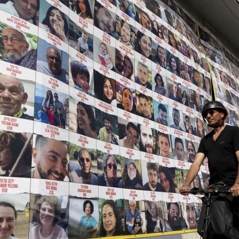  A man passes by a building covered with photos of hostages who have been released or are still being held in the Gaza Strip, on March 26, 2024 in Tel Aviv, Israel. Foreign mediators in the ongoing Israel-Hamas ceasefire negotiations have expressed cautious optimism about the talks, but a breakthrough remains elusive. Israel has vowed that it will still press on with a ground invasion of Rafah, the Gaza Strip's southernmost city, even if a temporary ceasefire is agreed to.(Photo by Amir Levy/Getty Images)