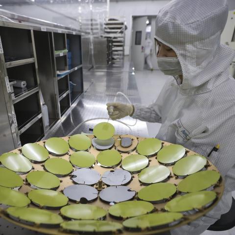 An employee processes chips at a workshop of Jiangsu Aoyang Shunchang Photoelectric Technology Co., Ltd. on May 11, 2024 in Huaian, Jiangsu Province of China. (Photo by Zhao Qirui/VCG via Getty Images)