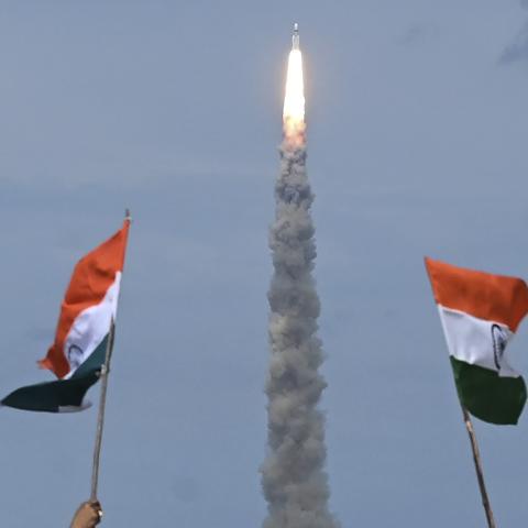 People wave Indian flags as an Indian Space Research Organisation (ISRO) rocket carrying the  Chandrayaan-3 spacecraft lifts off from the Satish Dhawan Space Centre in Sriharikota, an island off the  coast of southern Andhra Pradesh state, on July 14, 2023. (Photo by R.Satish Babu/AFP via Getty Images)
