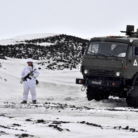A Russian serviceman stands guard by a military truck on the island of Alexandra Land on May 17, 2021. (Maxime Popov/AFP via Getty Images)
