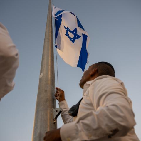 Workers raise the Israeli flag at the Western Wall before the "In Memoriam of 1,400 Souls: Special Candle-Lighting Ceremony" begins marking 30 days since the Oct 7th Hamas attack, at the Western Wall on November 6, 2023 in Jerusalem. Families of victims killed, as well as those hostages and others effected participated in the ceremony, which included the lighting of over 1400 yahrzeit Memorial candles. (Photo by Alexi J. Rosenfeld/Getty Images)
