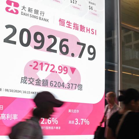 Pedestrians walk past a sign showing the numbers of the Hang Seng Index in Hong Kong on October 8, 2024. Hong Kong stocks plunged more than nine percent on October 8, their biggest fall in 16 years, after China left investors disappointed by a lack of new stimulus and few details about measures announced last month. (Photo by Peter PARKS / AFP) (Photo by PETER PARKS/AFP via Getty Images)
