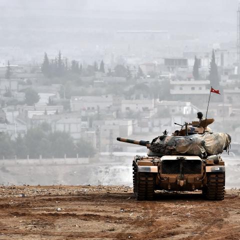Turkish soldiers on a tank sit opposite the town of Ain al-Arab, Syria, on October 11, 2014. (Aris Messinis via Getty Images)