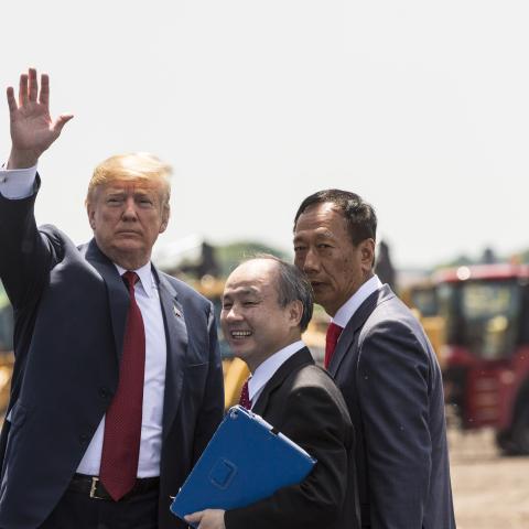 U.S. President Donald Trump (L) waves as Foxconn CEO Terry Gou (R) and Masayoshi Son, chairman and CEO of SoftBank Group watch at the groundbreaking for the Foxconn Technology Group computer screen plant on June 28, 2018 in Mt Pleasant, Wisconsin. Foxconn has committed to build a $10 billion plant in what it has named the Wisconn Valley Science and Technology Park, and to creating 13,000 Wisconsin jobs. (Photo by Andy Manis/Getty Images)