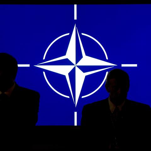 Participants sit in front of the NATO logo during the NATO summit in Newport, South Wales, on September 4, 2014. (Maurizio Gambarini via Getty Images)