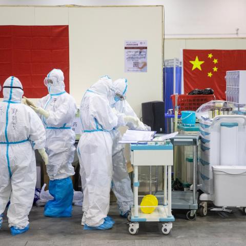 This photo taken on February 17, 2020 shows medical staff members working at an exhibition centre converted into a hospital in Wuhan in China's central Hubei province (Photo by STR/AFP via Getty Images)