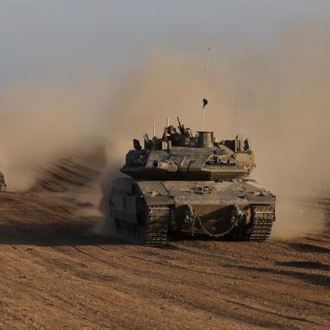An Israeli soldier gestures from the top of army vehicle near the Israeli border fence with the Gaza Strip, on December 10, 2024, as the war between Israel and Hamas continues in Gaza. (Photo by Menahem KAHANA / AFP) (Photo by MENAHEM KAHANA/AFP via Getty Images)