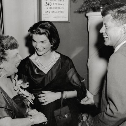 Senator and Mrs. John Kennedy are greeted by Perle Mesta. (Getty Images) 