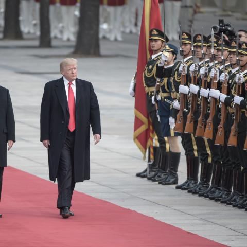 China's President Xi Jinping and US President Donald Trump review Chinese honour guards during a welcome ceremony at the Great Hall of the People in Beijing on November 9, 2017. (Fred Dufour/AFP via Getty Images)