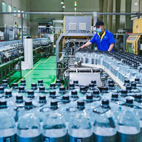 An employee checks the production line of drink bottles at the workshop of Changji Baolong Packaging Technology Development Co., Ltd. on May 6, 2024 in Changji Hui Autonomous Prefecture, Xinjiang Uygur Autonomous Region of China. (Photo by Tao Weiming/VCG via Getty Images)
