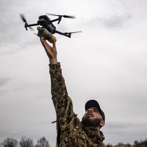 A Ukrainian soldier holds an FPV drone at arm’s length during military exercises on March 15, 2025, in Donetsk Oblast, Ukraine. (Roman Chop via Getty Images)