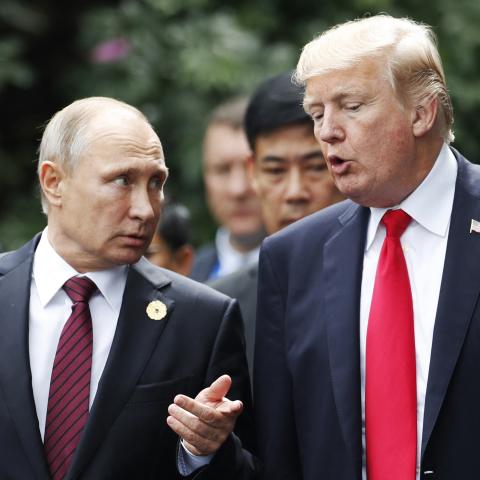 US President Donald Trump (R) and Russia's President Vladimir Putin talk as they make their way to take the "family photo" during the Asia-Pacific Economic Cooperation (APEC) leaders' summit in the central Vietnamese city of Danang on November 11, 2017. World leaders and senior business figures are gathering in the Vietnamese city of Danang this week for the annual 21-member APEC summit. (Photo by JORGE SILVA / POOL / AFP) (Photo by JORGE SILVA/POOL/AFP via Getty Images)
