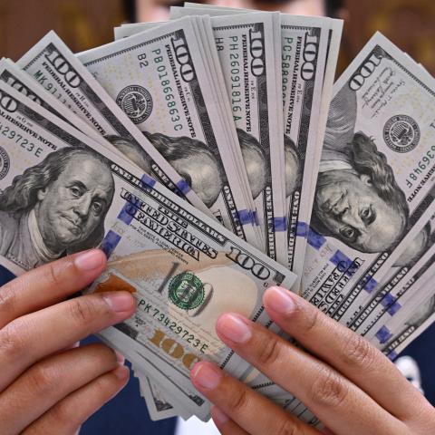 A clerk poses with United States dollar banknotes at a money changer in Jakarta, Indonesia, on May 2, 2024. (Adek Berry/AFP via Getty Images)