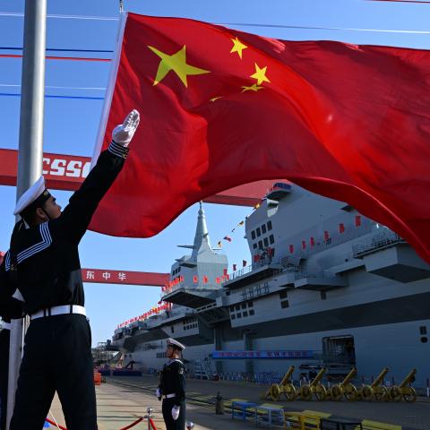 A flag-raising ceremony is held during the launching ceremony to unveil China's first Type 076 new-generation amphibious assault ship, the Sichuan, at Hudong-Zhonghua Shipbuilding, a Shanghai-based subsidiary of China State Shipbuilding Corp, on December 27, 2024 in Shanghai, China. Named after southwest China's Sichuan Province, the independently-developed new vessel was put into the water at a launch and naming ceremony. (Photo by Pu Haiyang/VCG via Getty Images)