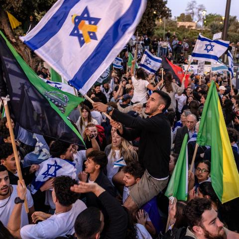 Demonstrators hold military and Israeli flags during a protest in front of the Knesset (Israeli parliament) in Jerusalem on April 2, 2025, calling for the goverment to enforce the mandatory military service to all people, including ultra-Orthodox Jewish men. (Photo by Menahem KAHANA / AFP) (Photo by MENAHEM KAHANA/AFP via Getty Images)