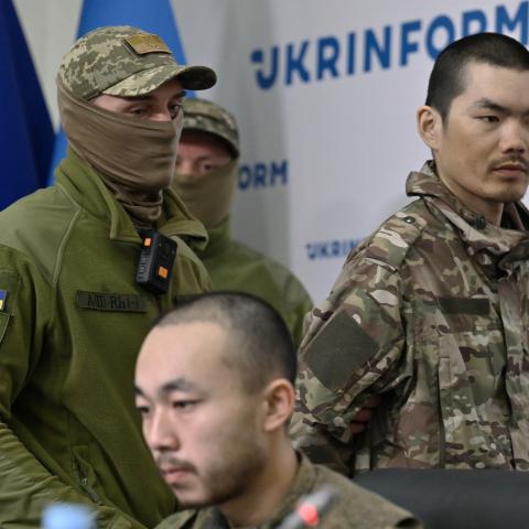 A serviceman of Security Service of Ukraine escorts Chinese prisoner of war in Kyiv on April 14, 2025, amid the Russian invasion of Ukraine. (Genya Savilov/AFP via Getty Images)