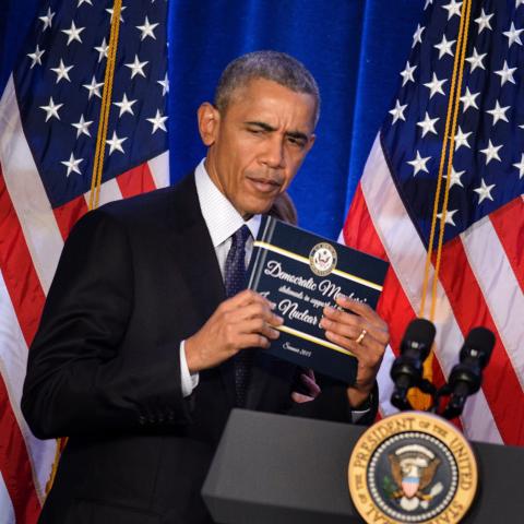 President Barack Obama holds a copy of the Iran nuclear agreement presented to him by House Minority Leader Nancy Pelosi during the House Democratic Issues Conference on January 28, 2016, in Baltimore, Maryland. (Brendan Smialowski via Getty Images)