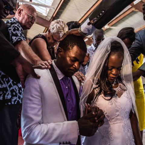 Bride and groom Sharon and McVivien kneel as elders pray over them following their nuptials mass during their wedding ceremony in Nairobi, Kenya, on February 13, 2016. (Fredrik Lerneryd/AFP via Getty Images)