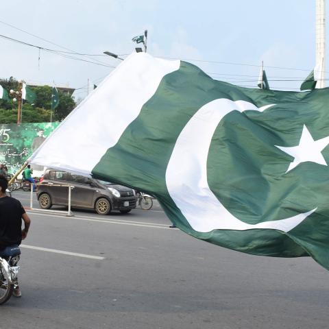 People hold a Pakistani national flag on a motorbike to celebrate the country's Independence Day in Lahore, Pakistan, on Aug. 14, 2022. (Sajjad/Xinhua via Getty Images)