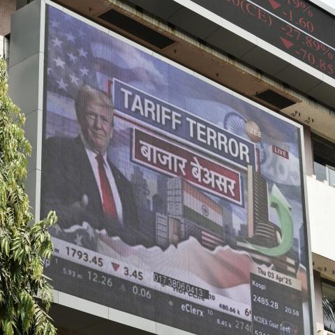 A broadcast screen at the Bombay Stock Exchange in Mumbai, India, on April 3, 2025, displays news of US President Donald Trump announcing sweeping new trade tariffs. (Indranil Aditya via Getty Images)