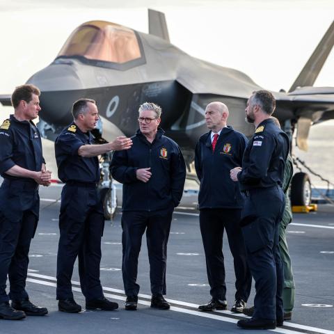Britain's Prime Minister Keir Starmer and Britain's Defence Secretary John Healey stand in front of a Royal Navy F-35B Lightning fighter jet on the flight deck of the British aircraft carrier HMS Prince Of Wales on April 24, 2025. (Richard Pohle via Getty Images)