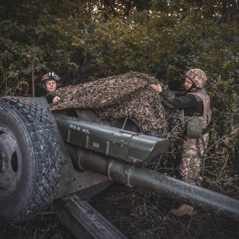 Soldiers pulling down camouflage netting from a 122 mm howitzer 2A18 before combat work as Ukrainian forces with the 117th territorial defense brigade operate an artillery position on June 19, 2025 in the Sumy region of Ukraine. (Nikoletta Stoyanova via Getty Images)