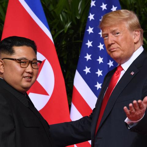 US President Donald Trump (R) gestures as he meets with North Korea's leader Kim Jong Un (L) at the start of their historic US-North Korea summit, at the Capella Hotel on Sentosa island in Singapore on June 12, 2018. (Saul Loeb via Getty Images)