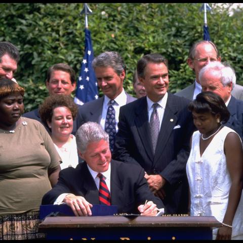 President Bill Clinton signs a welfare reform bill in the White House Rose Garden on August 21, 1996. (Dirck Halstead via Getty Images)