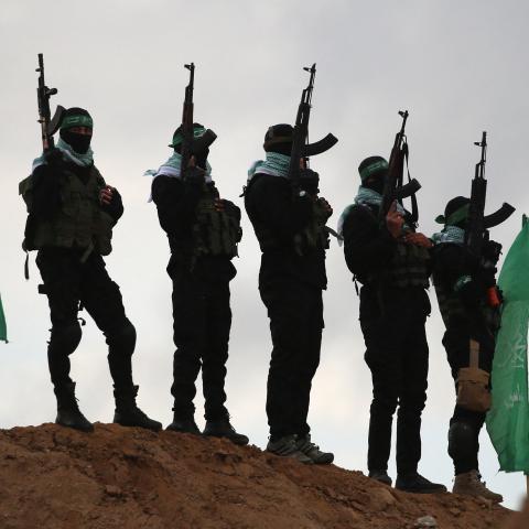 Palestinian Hamas militants gather at the site of the handing over of the bodies of four Israeli hostages in Khan Yunis in the southern Gaza on February 20, 2025. (Eyad Baba via Getty Images)