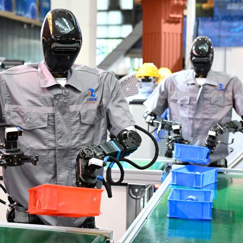 Qinglong humanoid robots sort goods at a logistics sorting line during the 2025 World Artificial Intelligence Conference at the Shanghai World Expo Exhibition and Convention Center on July 26, 2025. (Tian Yuhao via Getty Images)