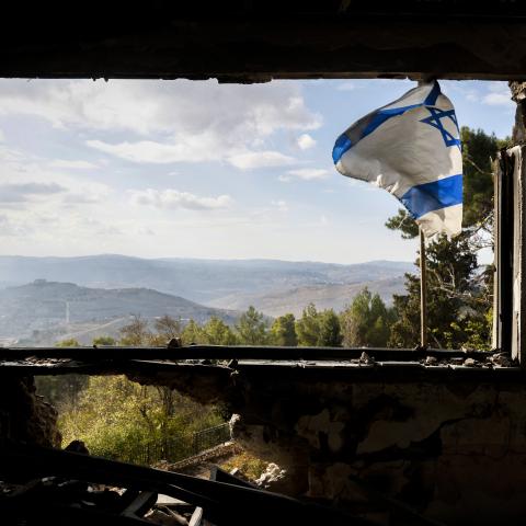  An Israeli flag flutters on the window of a building that was damaged during the war between Israel and Hezbollah in Kibbutz Menara in northern Israel on November 28, 2024. The Israeli military on November 28 said it hit a facility in southern Lebanon belonging to Iran-backed militant group Hezbollah, a day after a ceasefire between the group and Israel began. (Photo by Jalaa MAREY / AFP) (Photo by JALAA MAREY/AFP via Getty Images)