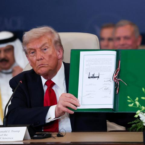 President Donald Trump poses with the signed agreement at a world leaders' summit on ending the Gaza war on October 13, 2025, in Sharm El-Sheikh, Egypt.