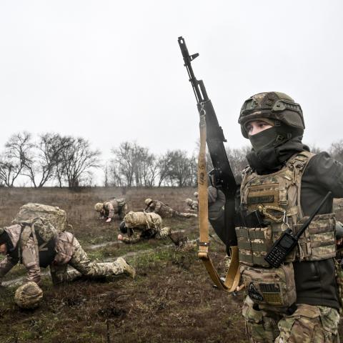 Recruits crawl a designated distance with combat gear under the supervision of instructors during the zero day of basic combined arms training with the 65th Separate Mechanized Brigade at an improvised training ground in Ukraine, on December 12, 2025 (Photo by Dmytro Smolienko/Ukrinform). NO USE RUSSIA. NO USE BELARUS. (Photo by Ukrinform/NurPhoto via Getty Images)