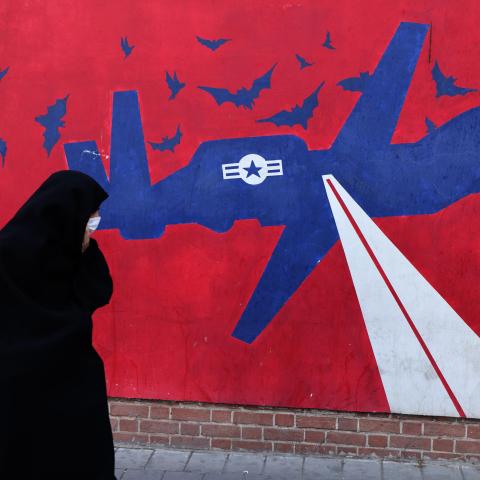 A woman walks past a mural depicting a US drone painted on the outer walls of the former US embassy in Tehran, on February 1, 2026. (Getty Images)