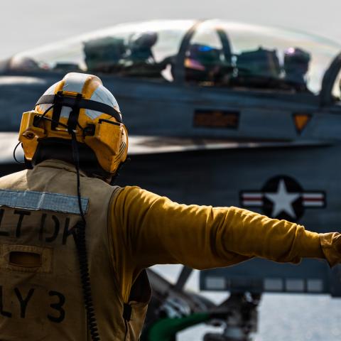 A U.S. Sailor signals to an F/A-18F Super Hornet aircraft, attached to Strike Fighter Squadron 213, as it approaches a catapult on the flight deck of the USS Gerald R. Ford (CVN 78), while underway, March 17, 2026. (U.S. Navy photo)