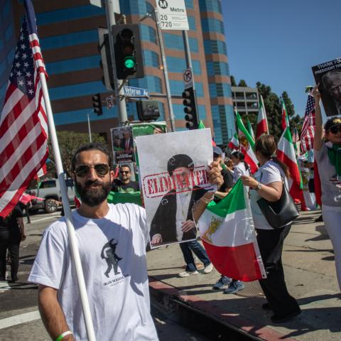 A man holds a US flag and a sign with a portrait of the late Supreme Leader Ayatollah Ali Khamenei as members of the Iranian community celebrate in Los Angeles on February 28, 2026. (Getty Images)