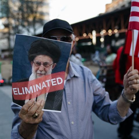 A man holds a US flag and a sign with a portrait of Iranian Supreme Leader Ayatollah Ali Khamenei on February 28, 2026, in Atlanta, Georgia. (Getty Images)