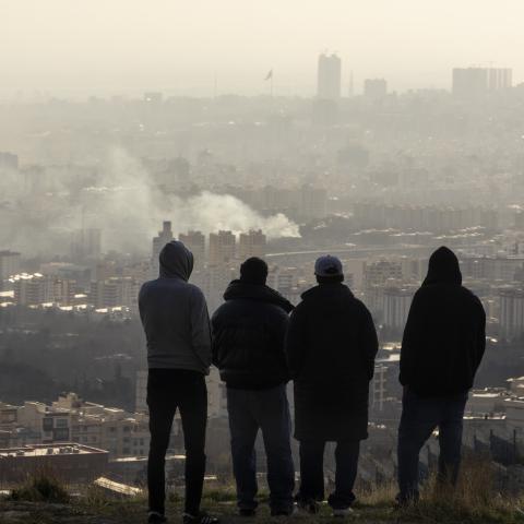 Men watch from a hillside as a plume of smoke rises after an explosion on March 2, 2026, in Tehran, Iran. (Getty Images)